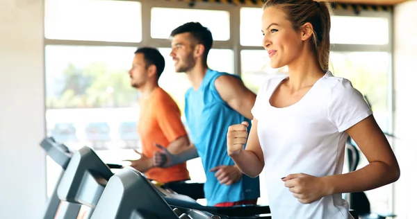 Amigos haciendo ejercicio en la máquina de cinta de correr — Foto de Stock