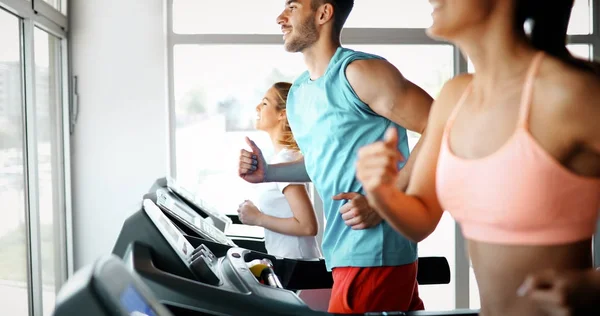 Amigos haciendo ejercicio en la máquina de cinta de correr — Foto de Stock