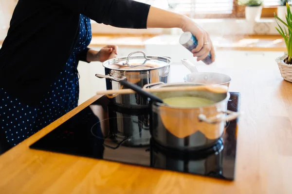 Donna che aggiunge spezie al cibo — Foto Stock