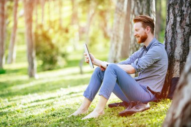 Parkta tablet kullanan bir işadamı