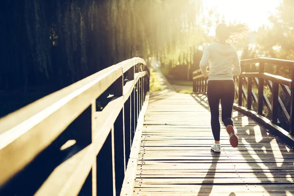 Female jogger running during sunset — Stock Photo, Image