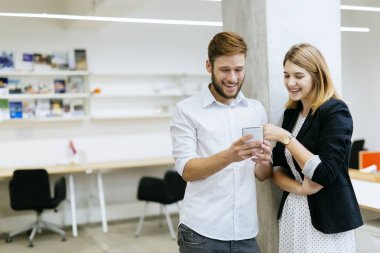 Ofiste telefona bakarken gülümseyen işadamı işkadını