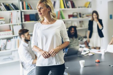 Arka planda arkadaşlarıyla ofiste güzel bir kadın portresi