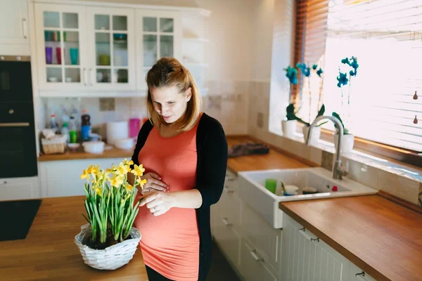 Mulher grávida cuidando de flores — Fotografia de Stock