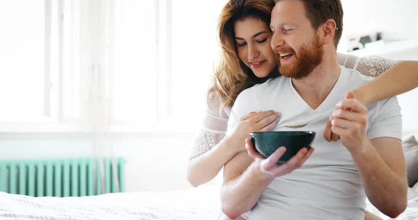 Casal tomando café da manhã na cama — Fotografia de Stock