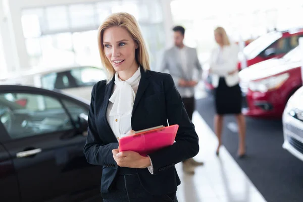 Salesperson working in car dealership — Stock Photo, Image