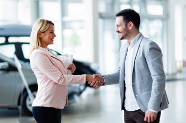 araba galerisinde alıcıya satan satış temsilcisi