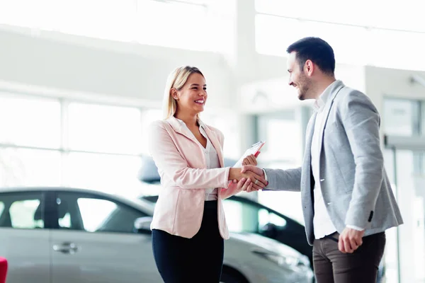 Salesperson selling cars at dealership to buyer — Stock Photo, Image