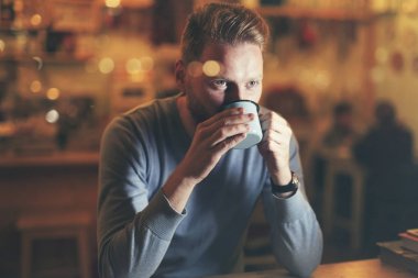 Genç yakışıklı adam kahve içiyor. 