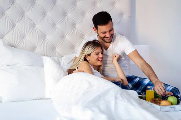 Casal tomando café da manhã na cama — Fotografia de Stock