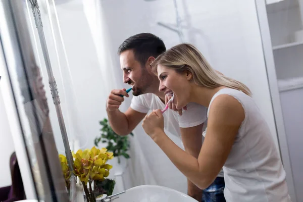 Attractive couple brushing teeth — Stock Photo, Image