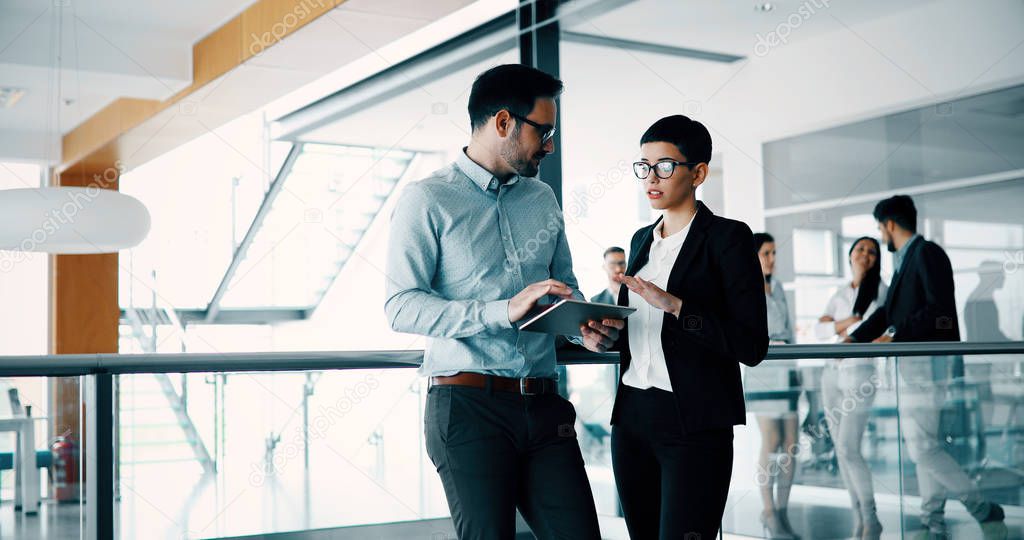 Happy business colleagues in modern office using tablet