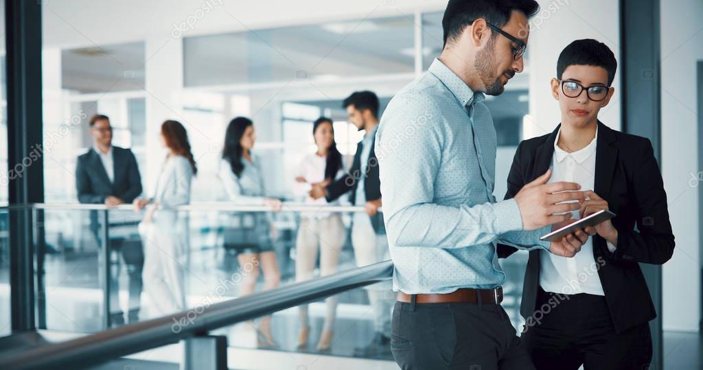 Happy business colleagues in modern office using tablet