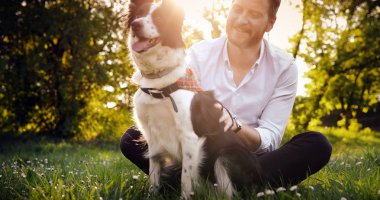 Adam köpeğini kucaklayan