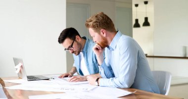 Bir grup mimar ve iş adamı birlikte çalışıyor ve beyin fırtınası yapıyorlar.