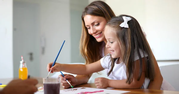 girl painting with her mother