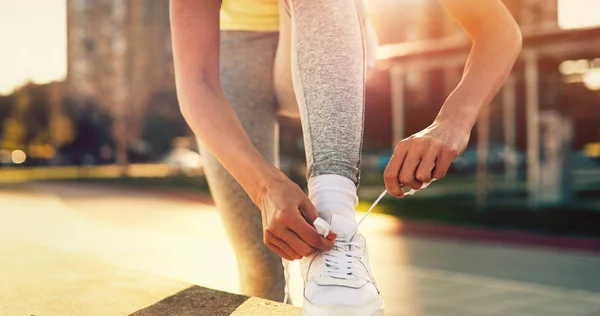 Привлекательная спортсменка завязывает шнурки и готовится к фитнесу — стоковое фото