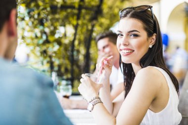 Bir masada açık havada oturma ve bir içecek içme güzel genç kadın