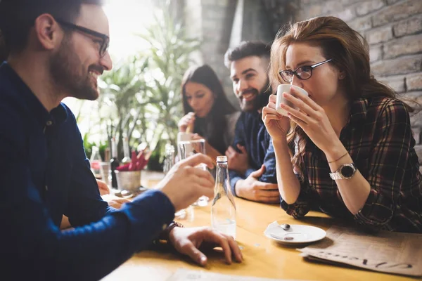 Gruppen av unga medarbetare umgås i restaurang — Stockfoto