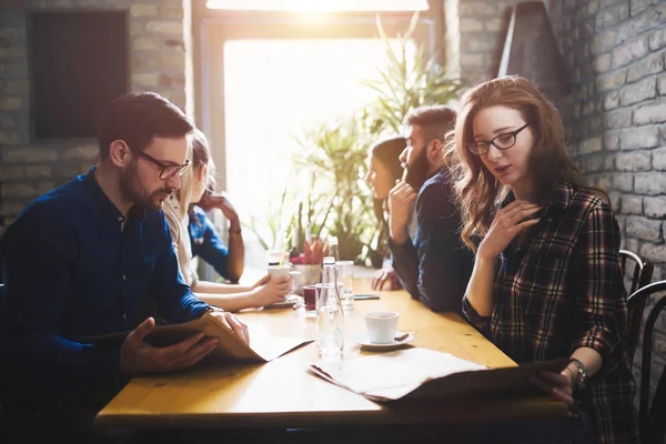 Group of young coworkers socializing in restaurant — Stock Photo, Image