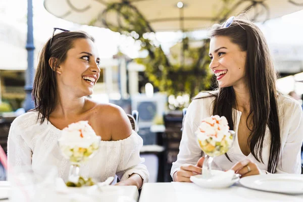 Gülümseyen ve bir meyve salatası sahip kadınlar