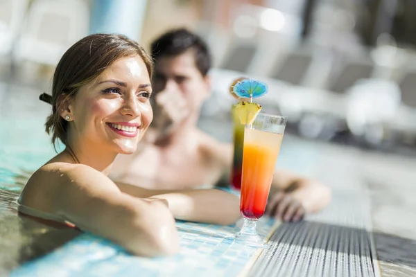 Paar trinkt einen Cocktail am Pool — Stockfoto
