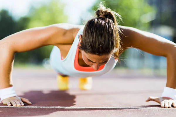 Young beautiful woman doing push-ups Stock Picture