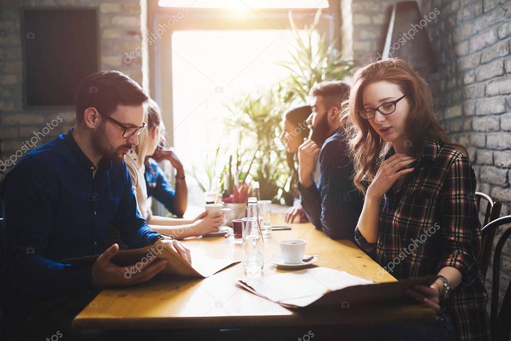 Group of young coworkers socializing in restaurant