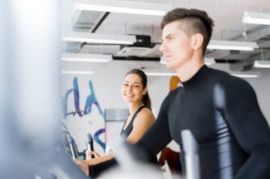 Eliptik bir eğitmen bir fitness merkezinde egzersiz insanların genç sağlıklı grup