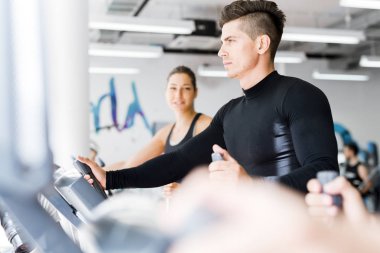 Eliptik bir eğitmen bir fitness merkezinde egzersiz insanların genç sağlıklı grup