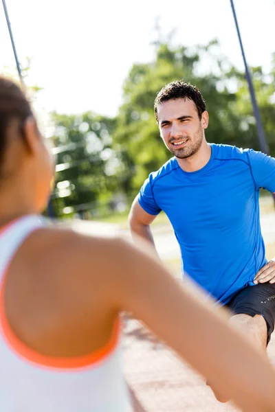 Hombre y mujer estirándose al aire libre — Foto de Stock