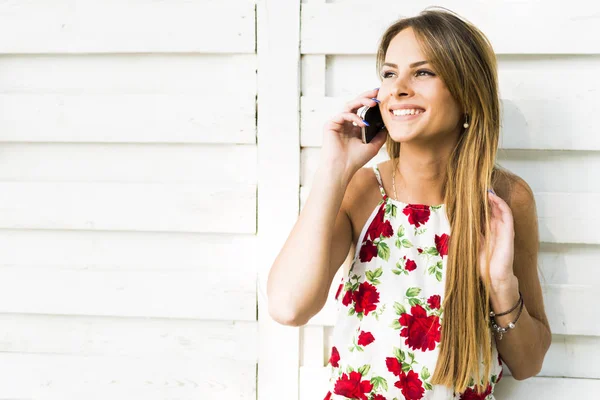 Женщина улыбается во время телефонного звонка — стоковое фото