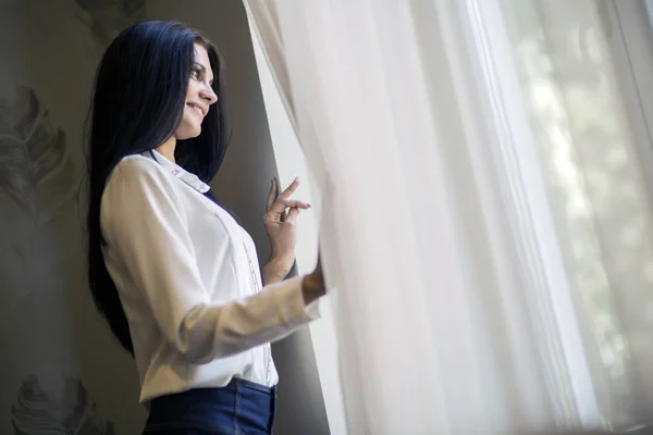 Donna che guarda fuori dalla finestra — Foto Stock