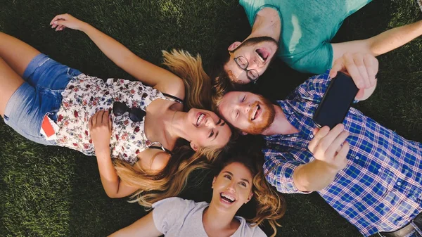 Jóvenes turistas descansando en la hierba — Foto de Stock