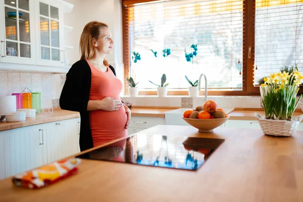 Όμορφη έγκυο γυναίκα στην κουζίνα — Φωτογραφία Αρχείου