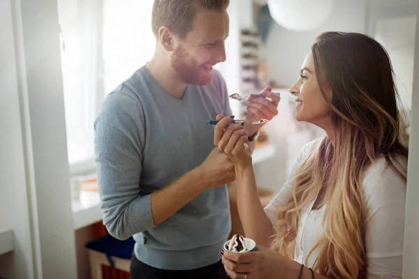 Couple s'amuser et rire à la maison tout en mangeant de la crème glacée — Photo