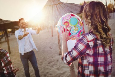 Gençlerin grup ile top yaz aylarında kumsalda oynarken mutlu