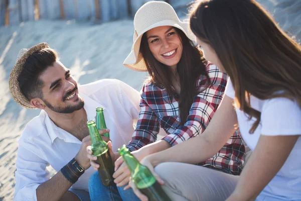Счастливые люди пьют на пляже — стоковое фото