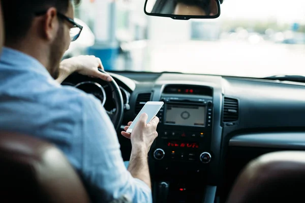 Hombre usando el teléfono mientras conduce el coche — Foto de Stock