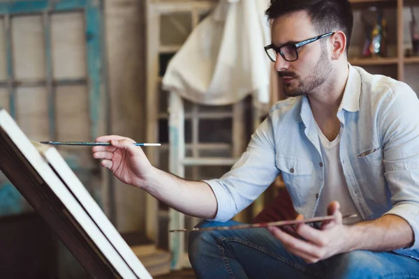 Männlicher Künstler arbeitet an der Malerei — Stockfoto