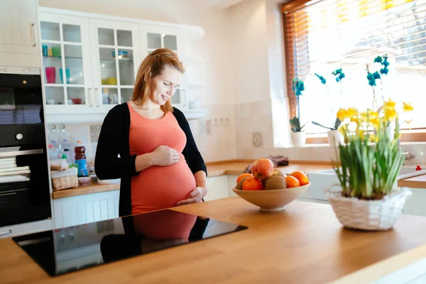 Красивая беременная женщина на кухне — стоковое фото