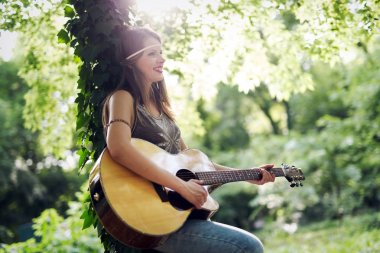 Güzel kadın doğada akustik gitar çalmak