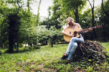 Güzel kadın doğada akustik gitar çalmak