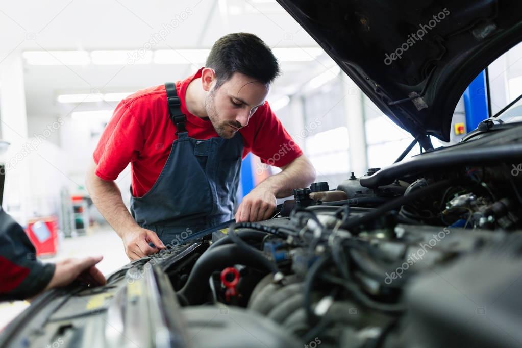 Handsome car mechanic working at automotive service center