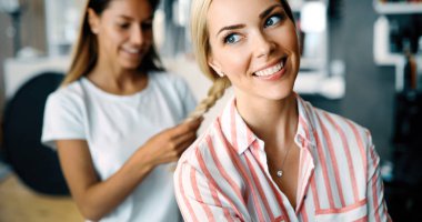 Mutlu genç kadın ve Kuaför Saç salonu stil sıcak yapmak fan ile