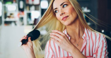 Çekici gülümseyen güzel kadın saçları fırçalama