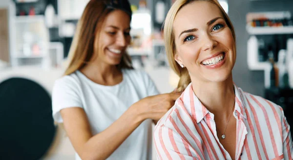幸福的年轻女人和风扇使热在美发沙龙造型美发师 — 图库照片