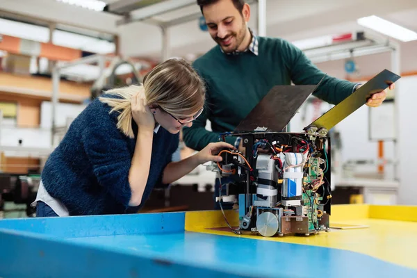 Estudiantes de robótica preparando robot para la prueba — Foto de Stock