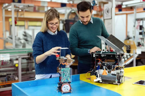 Estudiantes de robótica preparando robot para la prueba — Foto de Stock