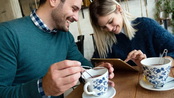 Hombre y mujer en la fecha mirando en la tableta — Foto de Stock